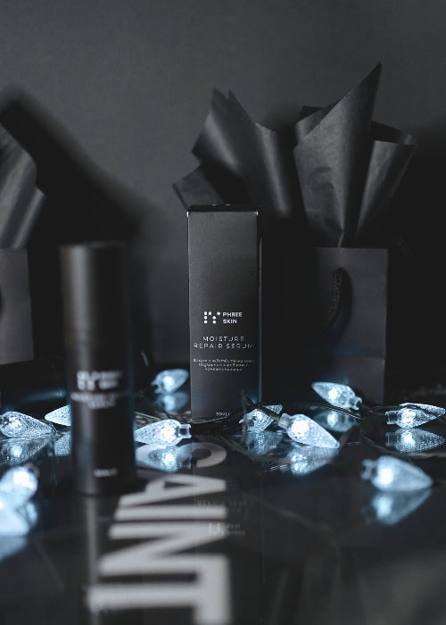 Cosmetic products on a reflective surface with a dark background