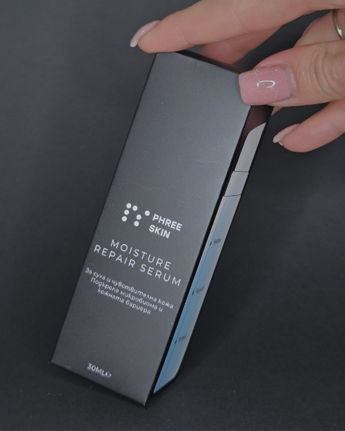 Hand holding a 'Phree Skin' moisture repair serum packaging against a dark background